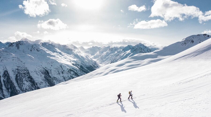 The pair ascends the mountain with poles