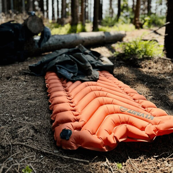 Insulated Static V™ Klymit® orange in forest inflatable mat. Photo: Rigad