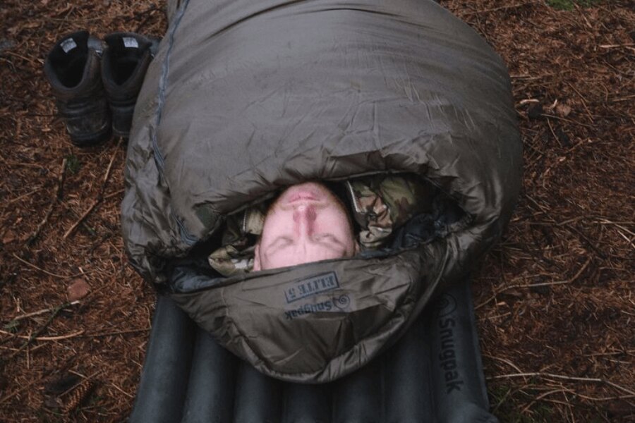 A man in a camo jacket sleeping on an inflatable mat in the Snugpak<sup>&reg;</sup> Softie<sup>&reg;</sup> Elite 5 sleeping bag. Source: Rigad, Snugpak