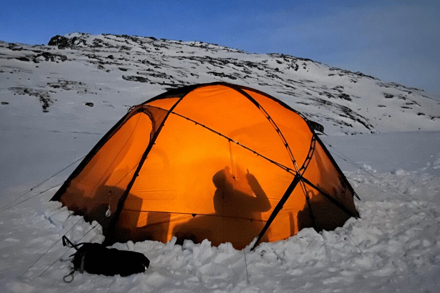 An orange tent in snow. Source: https://www.pexels.com/cs-cz/foto/ryma-studeny-snih-hory-20809686/