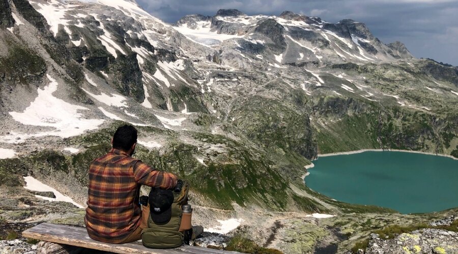 Man with a backpack on a bench in the mountains