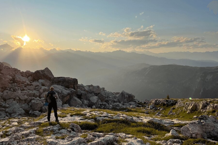 A man in the mountains watches the sunrise