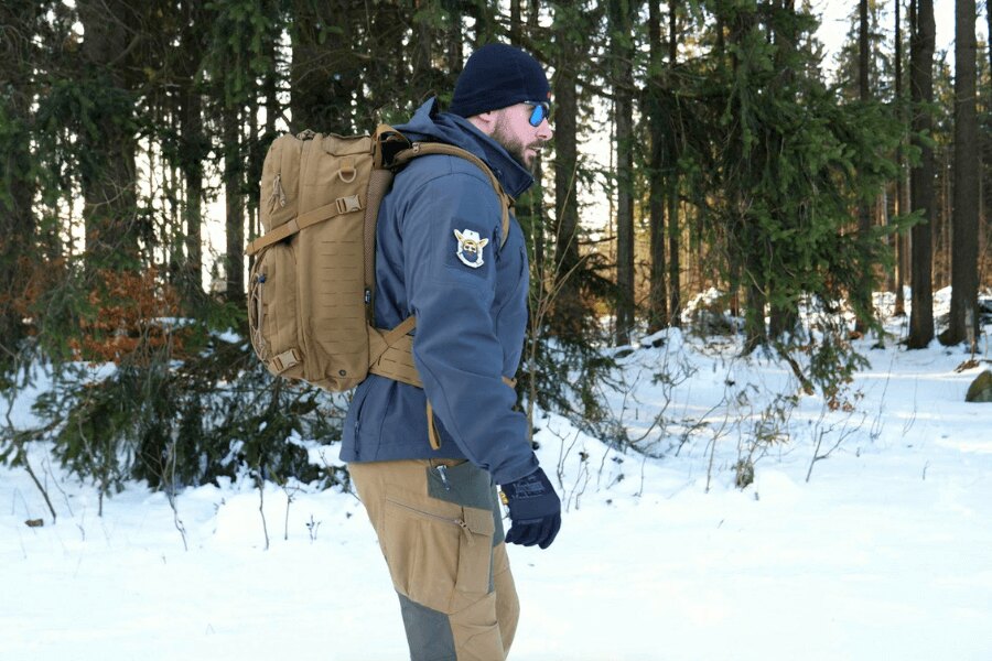 A functional jacket and a backpack in a snow-covered forest. Source: Rigad