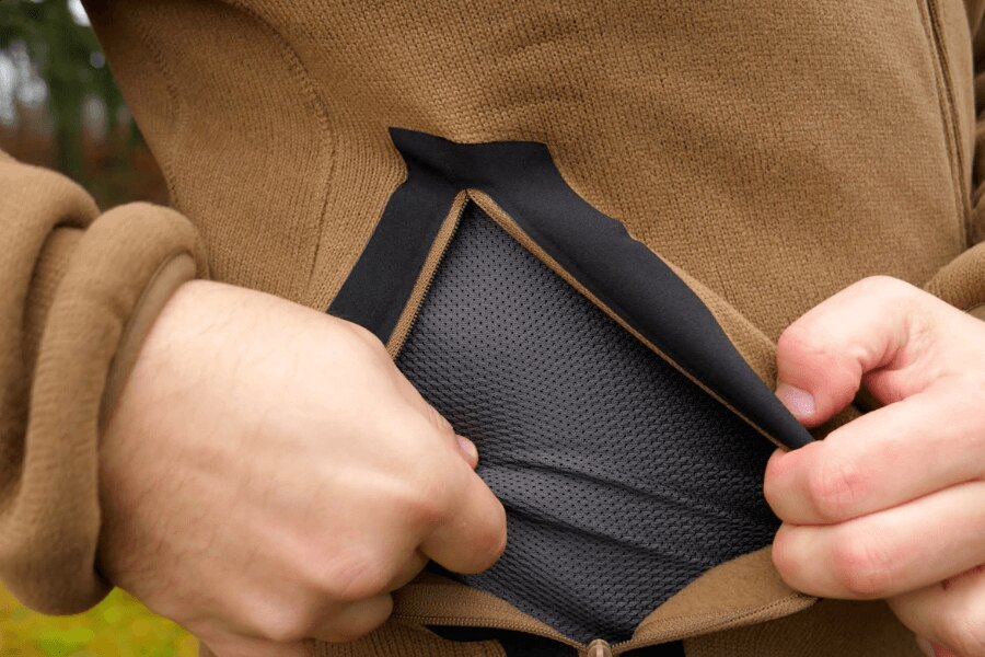 The second functional layer of outdoor clothing, detail of a pocket. Source: Rigad