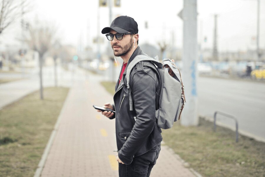 A man on the street with a backpack and a mobile phone. Source: https://www.pexels.com/cs-cz/foto/845457/