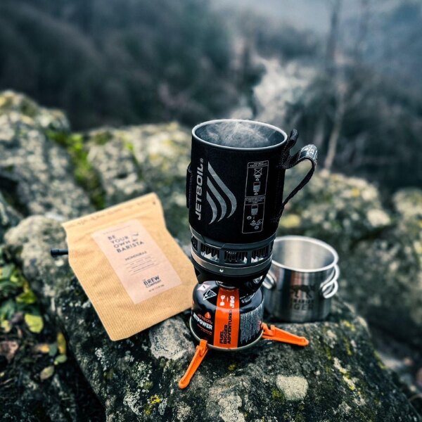 The JETBOIL<sup>&reg;</sup> MicroMo stove and coffee on a rock. Source: Rigad