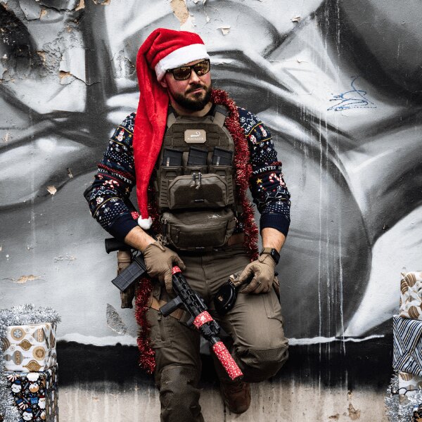 Lukáš as Santa Claus with a Christmas decorated rifle. Source: Rigad