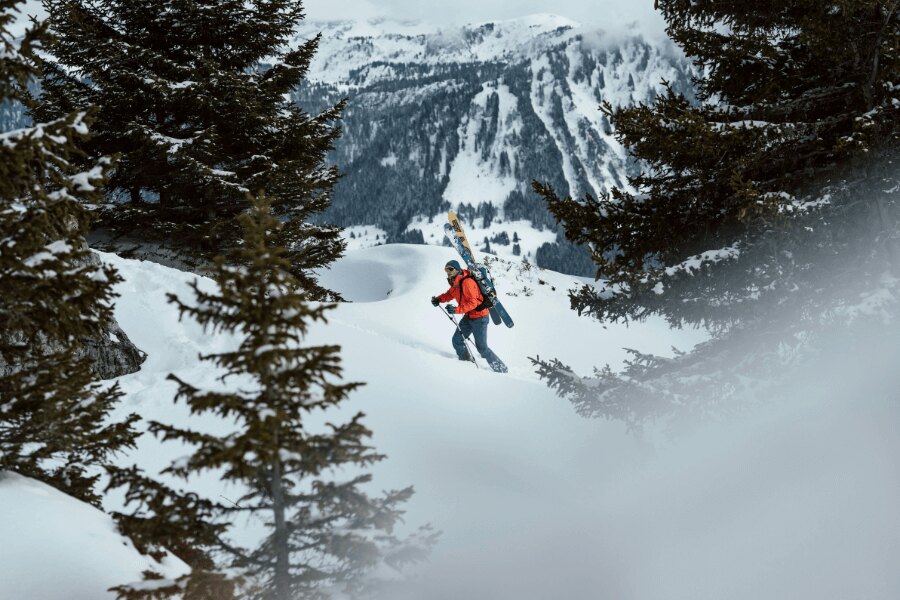 A man ascending with skialps on his back in winter countryside. Source: https://www.pexels.com/cs-cz/foto/ryma-studeny-snih-hory-24284368/