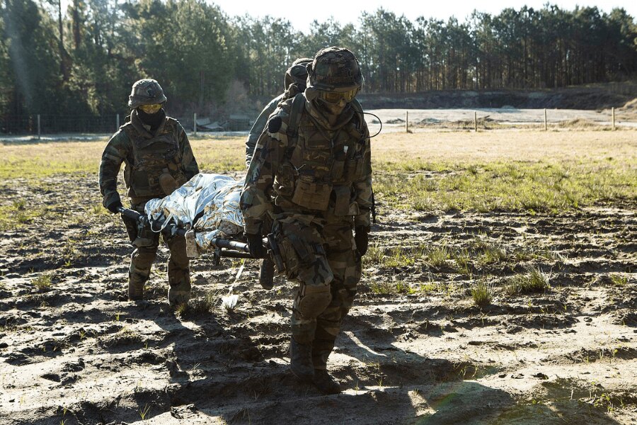 Soldiers carrying an injured person in a stretcher covered with an isothermal foil. Source: https://upload.wikimedia.org/wikipedia/commons/4/48/Dutch_Troop_Attack_160322-M-BZ307-198.jpg