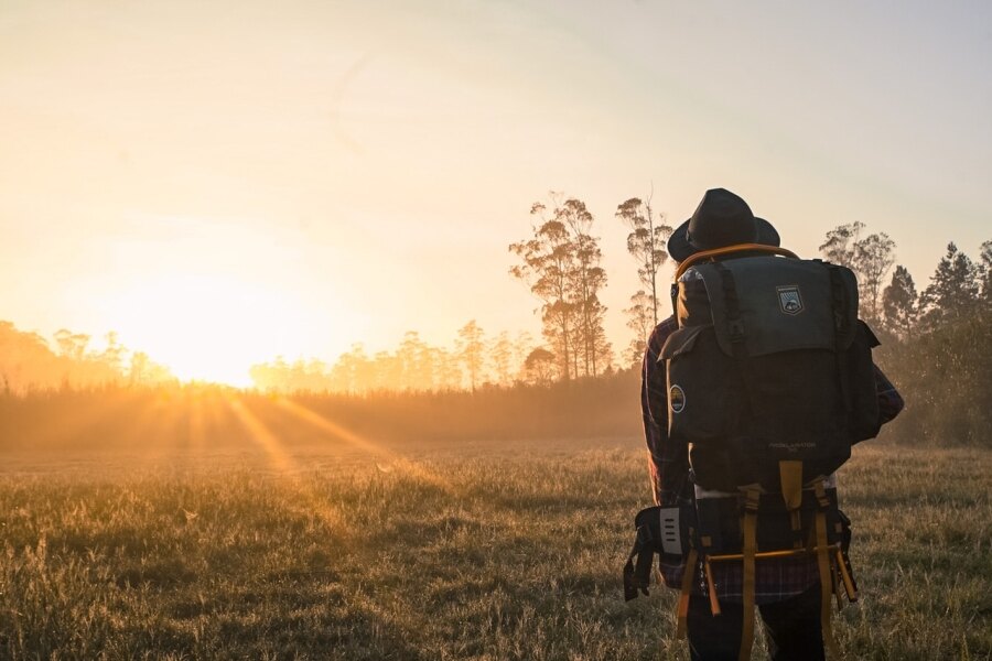 Man with a backpack observing the sunrise