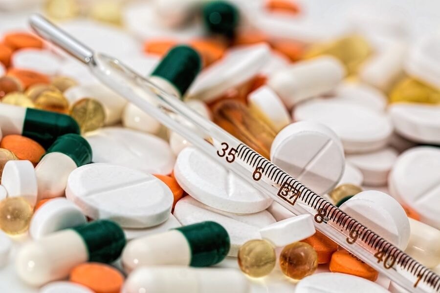 Pile of pills with thermometer